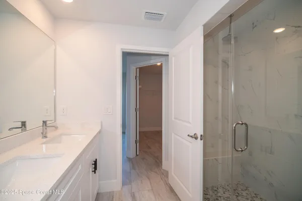 a bathroom with a double vanity sink a mirror and a shower
