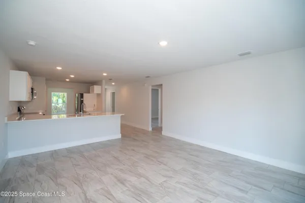 a view of kitchen with kitchen island microwave and wooden floor
