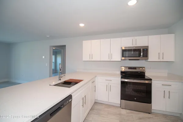 a kitchen with a sink stove and microwave