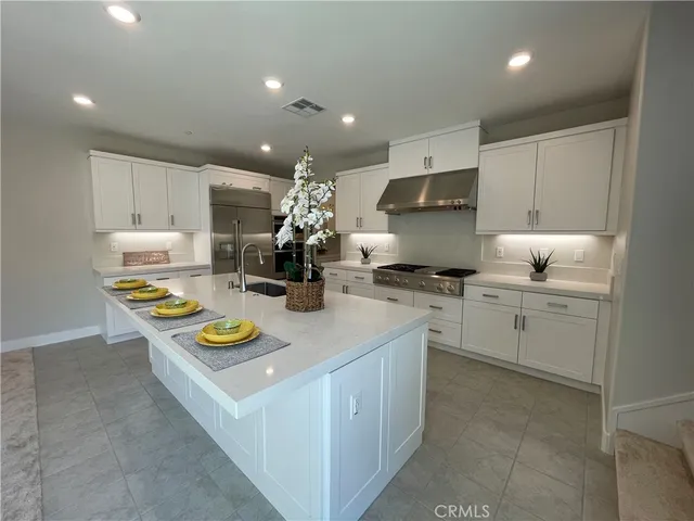 a kitchen that has a lot of cabinets in it with granite countertop stainless steel appliances