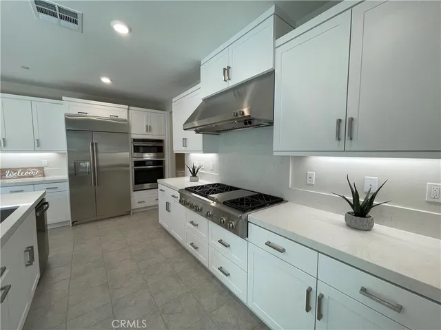 a kitchen with stainless steel appliances granite countertop a sink a stove and a refrigerator