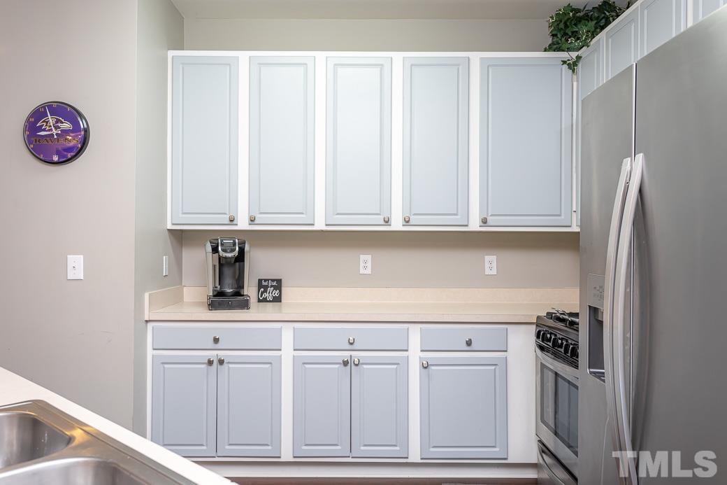 4439 Moss Garden Path Raleigh, NC 27616 - Photo 11 of 30 a kitchen with white cabinets and stainless steel appliances