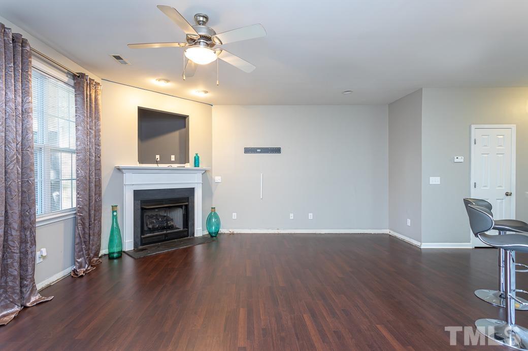 4439 Moss Garden Path Raleigh, NC 27616 - Photo 15 of 30 a view of empty room with wooden floor fireplace and fan