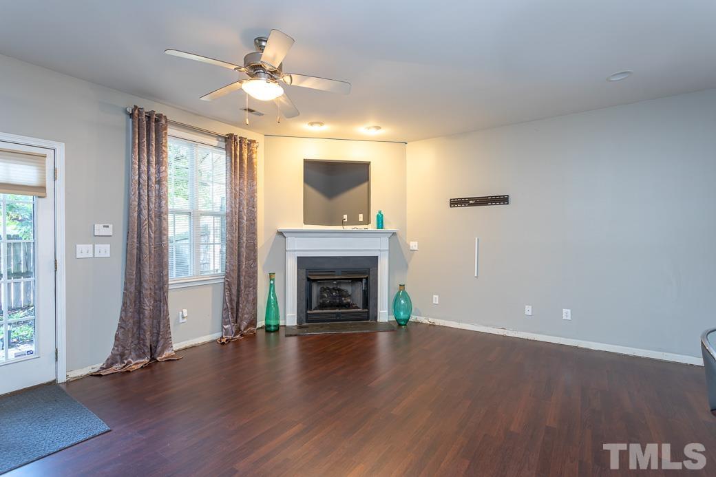 4439 Moss Garden Path Raleigh, NC 27616 - Photo 16 of 30 an empty room with windows fireplace and wooden floor