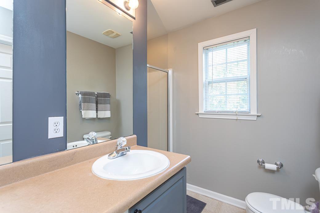 4439 Moss Garden Path Raleigh, NC 27616 - Photo 23 of 30 a bathroom with a sink vanity mirror and toilet