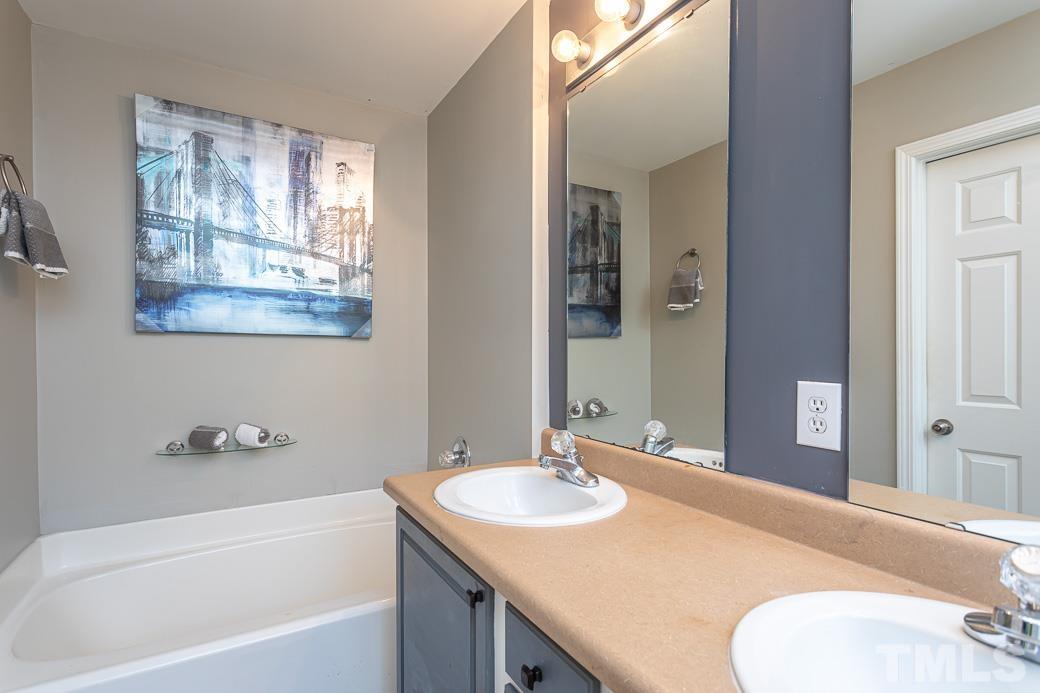 4439 Moss Garden Path Raleigh, NC 27616 - Photo 24 of 30 a bathroom with a granite countertop sink and a bathtub