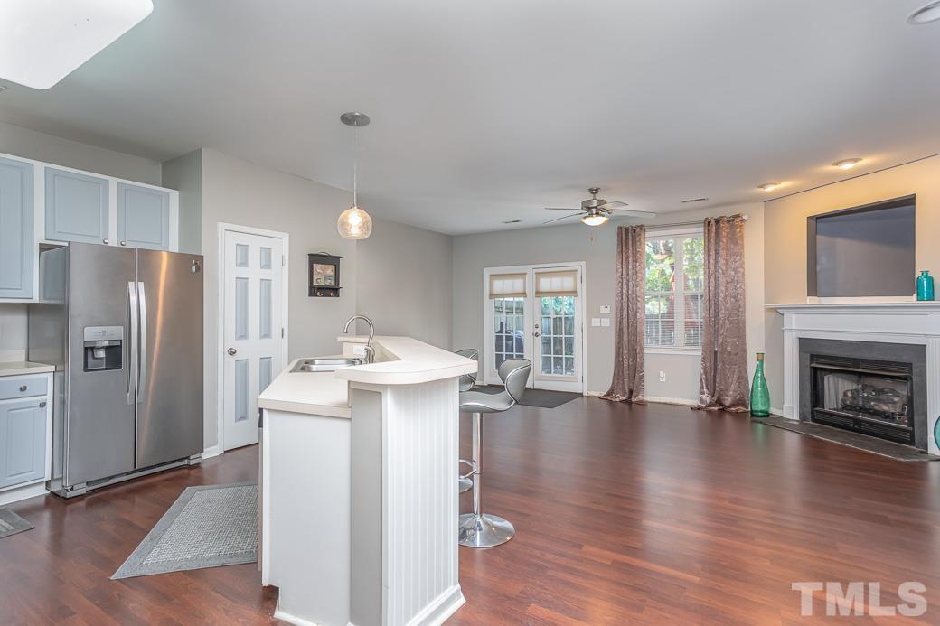 4439 Moss Garden Path Raleigh, NC 27616 - Photo 7 of 30 a kitchen with a refrigerator a sink dishwasher with a fireplace and wooden floor