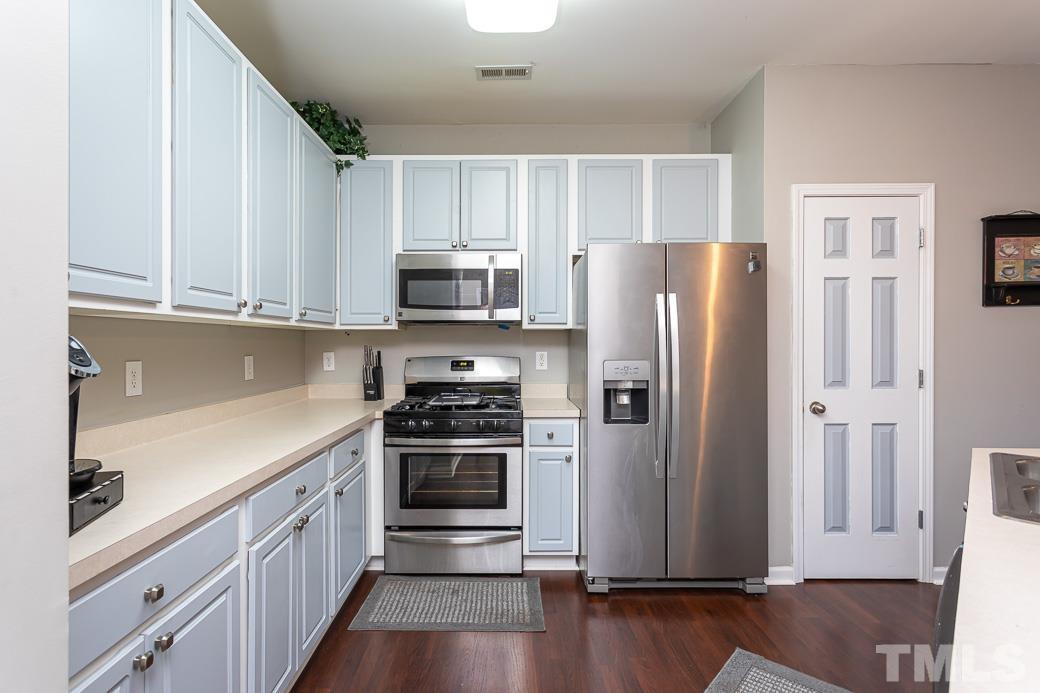 4439 Moss Garden Path Raleigh, NC 27616 - Photo 8 of 30 a kitchen with stainless steel appliances a refrigerator stove and sink