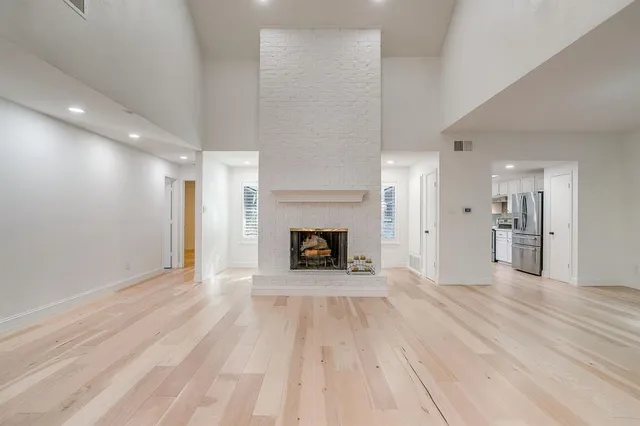 a view of a livingroom with wooden floor and a kitchen