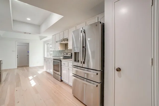 a kitchen with stainless steel appliances a refrigerator sink and microwave