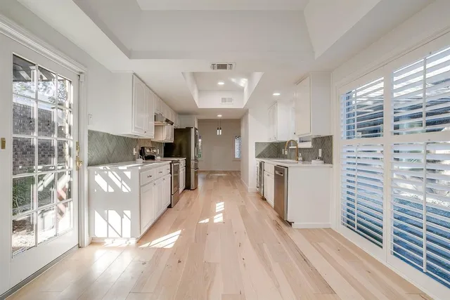 a kitchen with white cabinets and white appliances