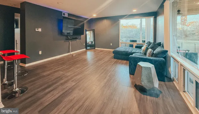 a living room with furniture and a wooden floor