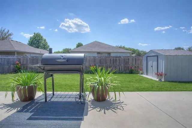 a view of a backyard with table and chairs and wooden fence