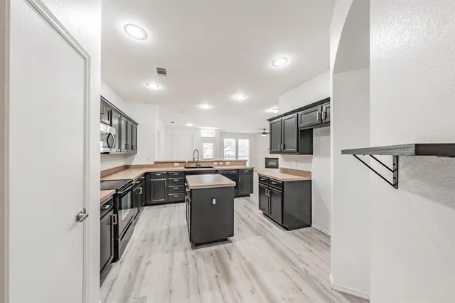a kitchen with stainless steel appliances granite countertop lots of counter top space and cabinets
