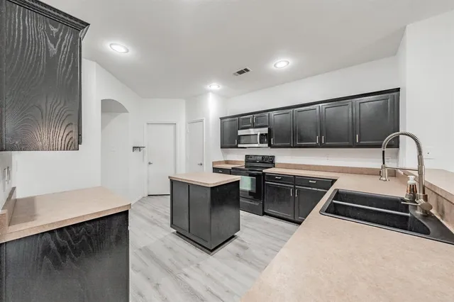 a kitchen with stainless steel appliances granite countertop a sink stove and refrigerator