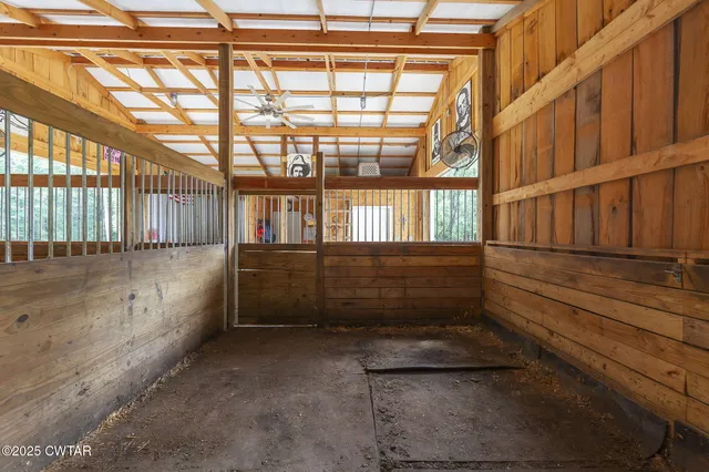 a view of an empty room with wooden floor and iron stairs