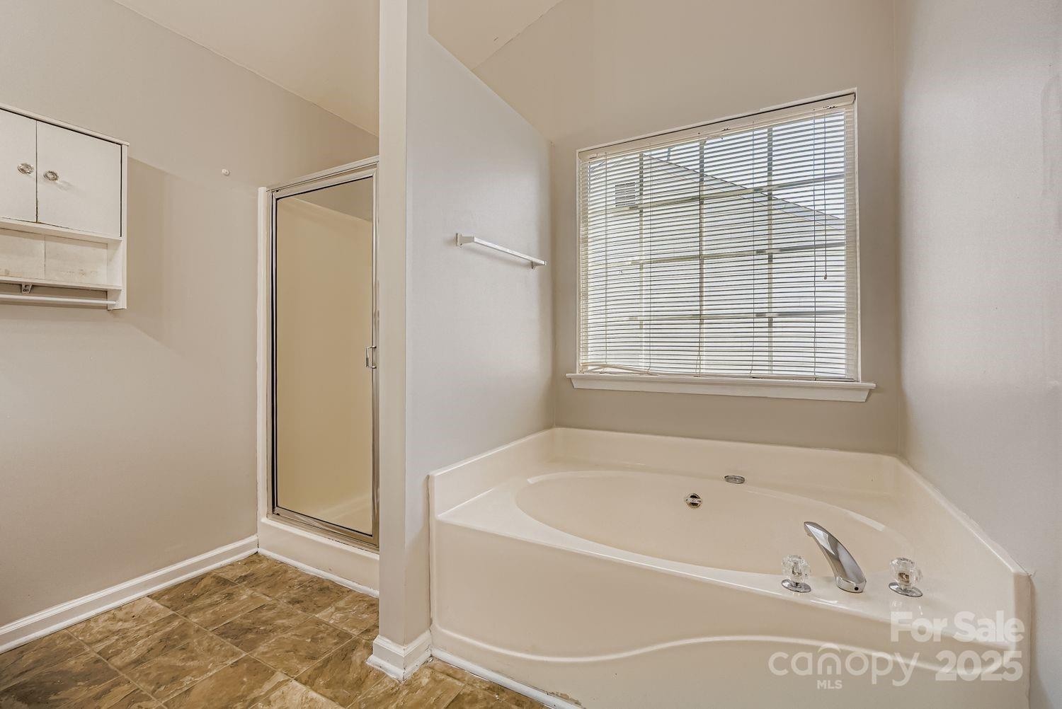 11609 Erwin Ridge Avenue Charlotte, NC 28213 - Photo 14 of 29 a white bath tub sitting in a bathroom next to a window