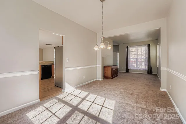 a view of a livingroom with a chandelier fan and windows