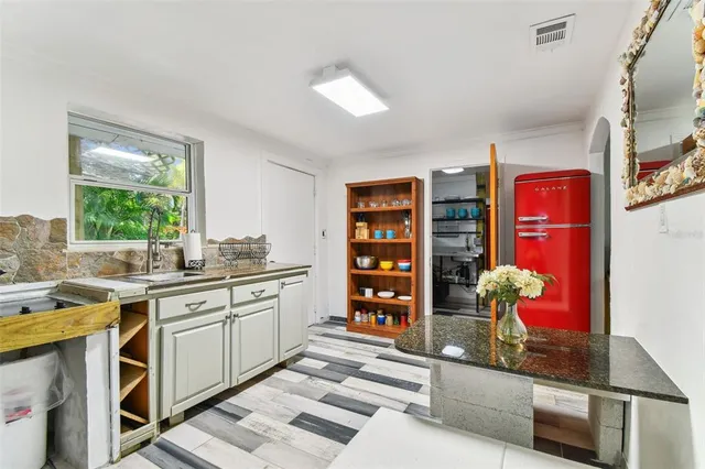 a kitchen with granite countertop a sink a window and stainless steel appliances
