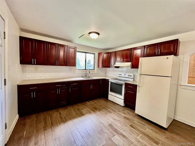 a kitchen with stainless steel appliances granite countertop a refrigerator a sink dishwasher a stove with wooden floors and cabinets