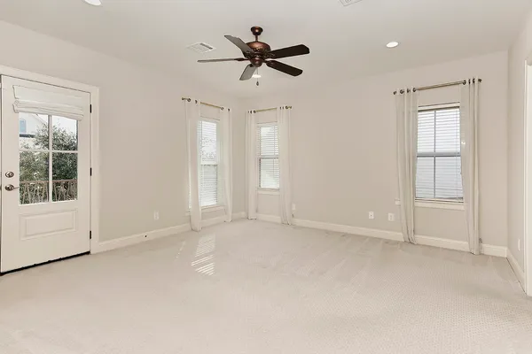 an empty room with ceiling fan and window