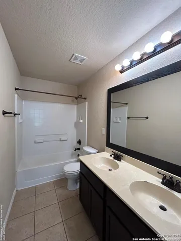 a bathroom with a double vanity sink toilet and mirror