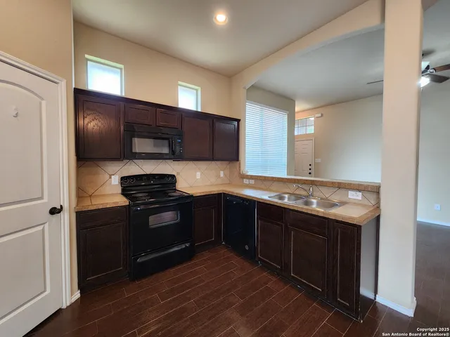 a kitchen with stainless steel appliances granite countertop wooden cabinets and a stove top oven