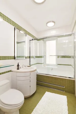 a bathroom with a bathtub sink and mirror