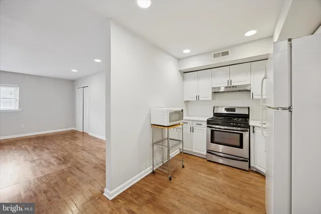 a kitchen with granite countertop a stove and a refrigerator