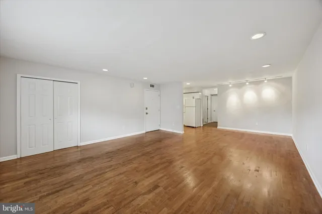 a view of an empty room with wooden floor