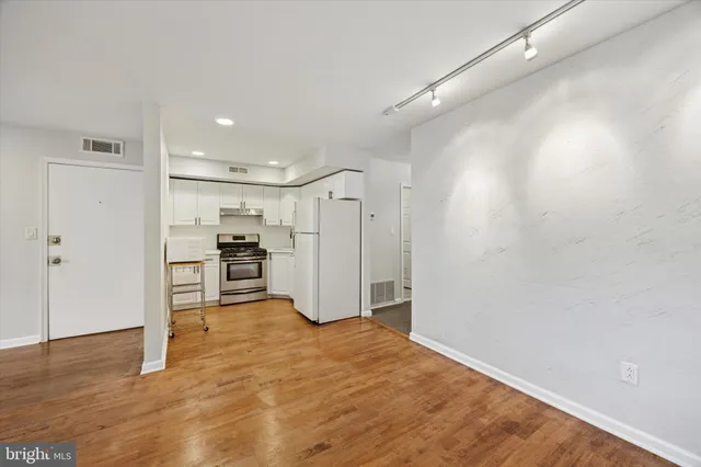 a view of kitchen with refrigerator and wooden floor