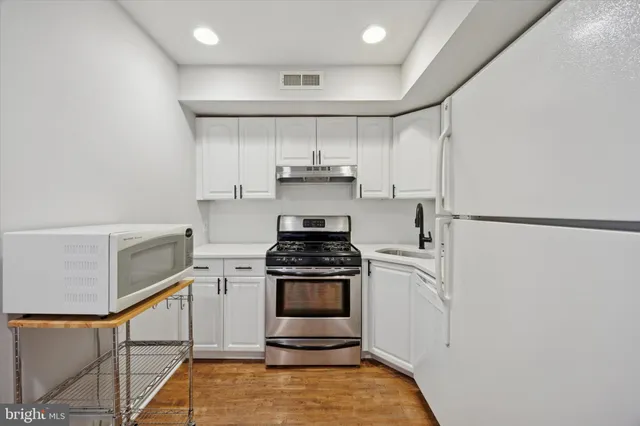 a kitchen with a stove and white cabinets