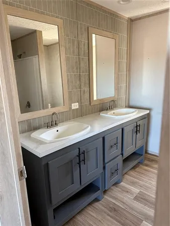 a bathroom with a double vanity sink and a mirror