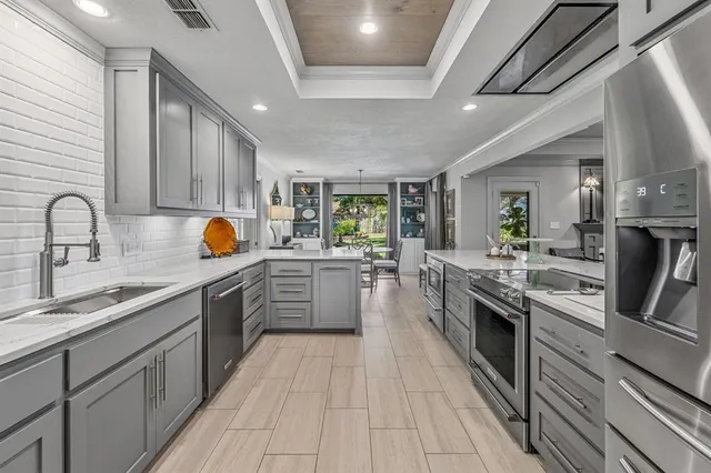 a large kitchen with stainless steel appliances kitchen island granite countertop a sink and cabinets