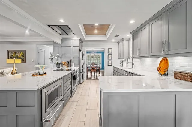 a kitchen with a sink and a stove with wooden floor
