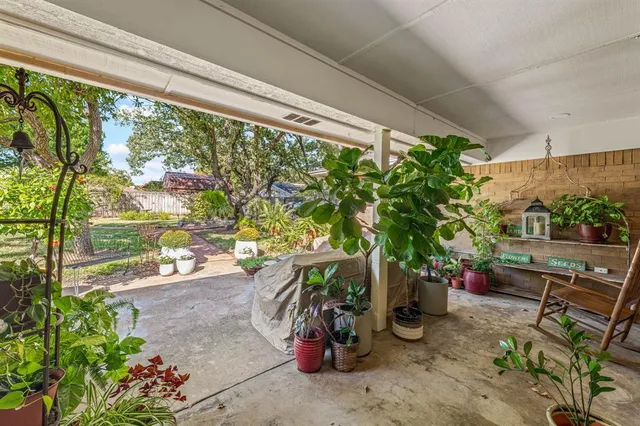 a view of backyard with table and chairs and wooden fence