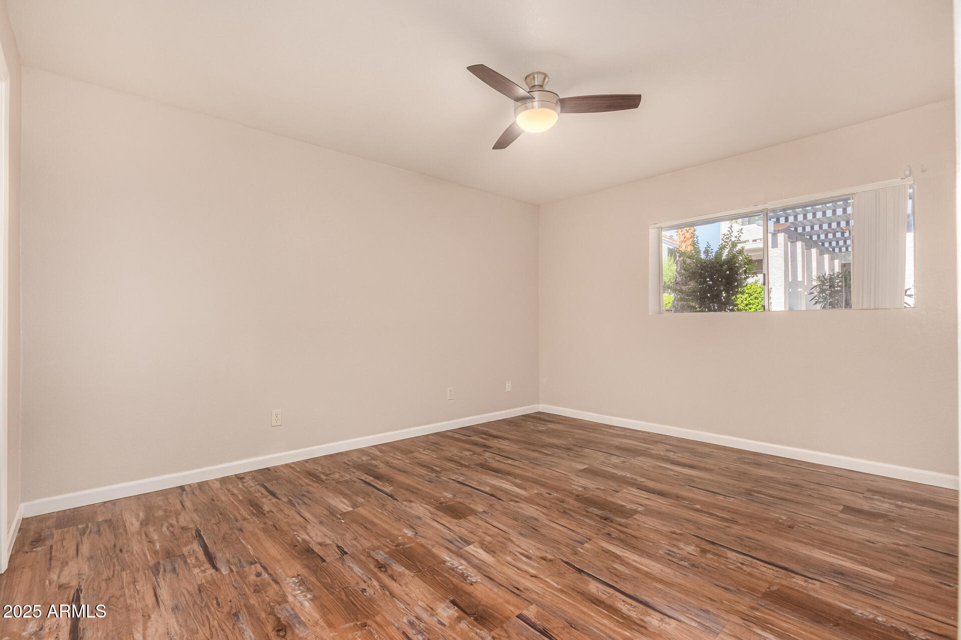 1331 West Baseline Road, Unit 167 Mesa, AZ 85202 - Photo 17 of 42 an empty room with wooden floor and windows