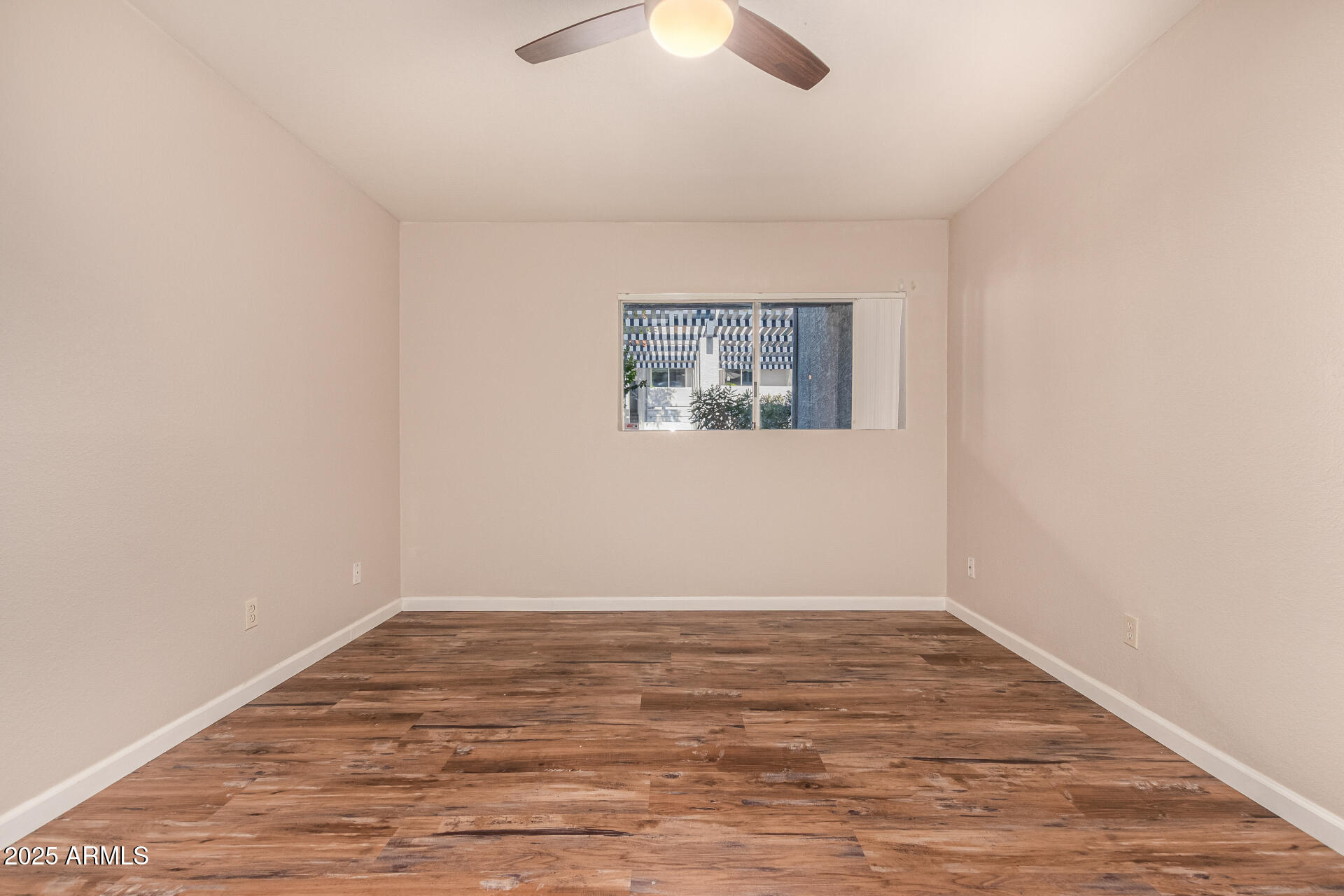 1331 West Baseline Road, Unit 167 Mesa, AZ 85202 - Photo 18 of 42 an empty room with wooden floor and windows