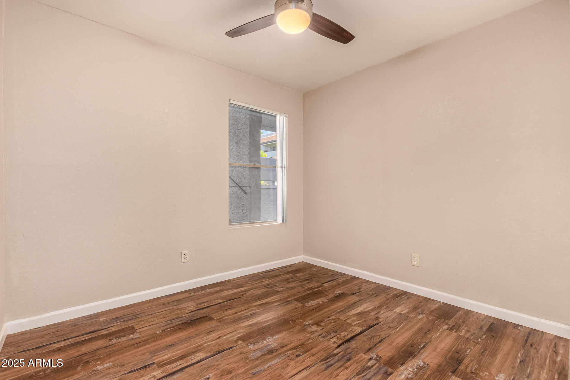 1331 West Baseline Road, Unit 167 Mesa, AZ 85202 - Photo 22 of 42 an empty room with wooden floor and windows