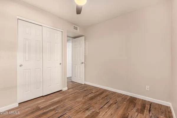 a view of an empty room with wooden floor