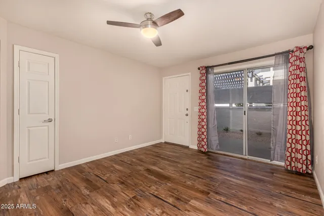 a view of empty room with wooden floor and ceiling fan