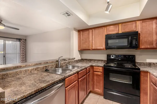 a kitchen with granite countertop a sink and steel appliances