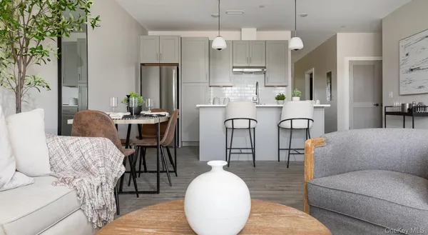 a kitchen with stainless steel appliances a dining table chairs and a refrigerator
