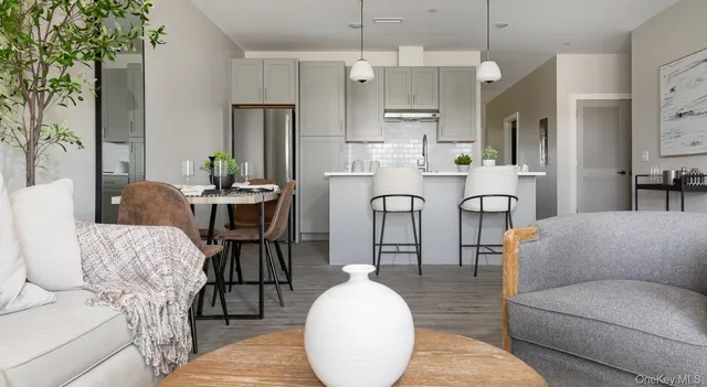 a kitchen with stainless steel appliances a dining table chairs and a refrigerator