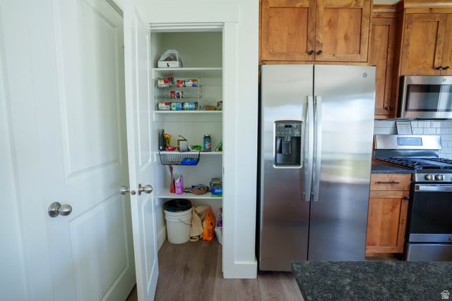 1486 West 2055th Street South Logan, UT 84339 - Photo 15 of 45 Stainless steel side-by-side refrigerator, wood-finish cabinetry, built-in microwave, gas range, and pantry with shelving