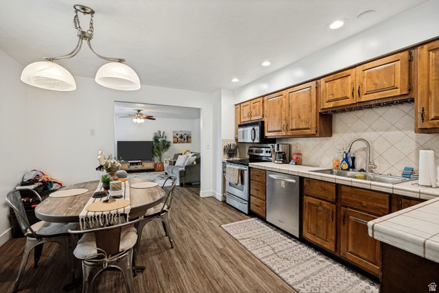 6709 Acoma Road, Unit 239 Midvale, UT 84047 - Photo 8 of 38 6711 - Wood-finish flooring, wood cabinetry, stainless steel appliances, recessed lighting, and a tile backsplash