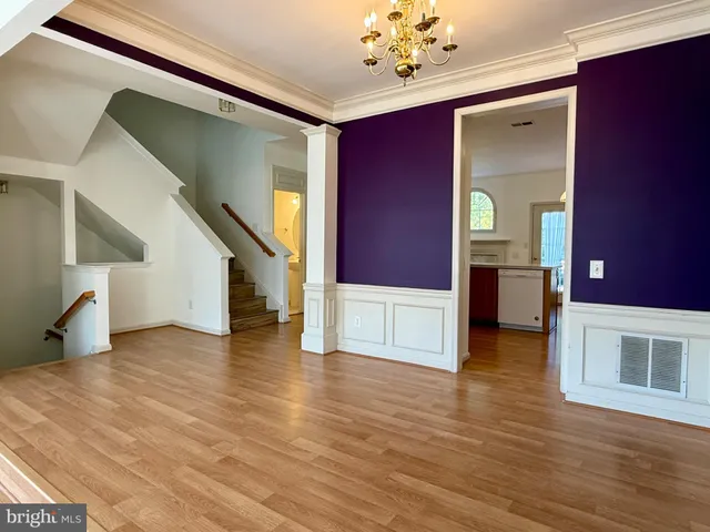 a view of a livingroom with wooden floor and stairs