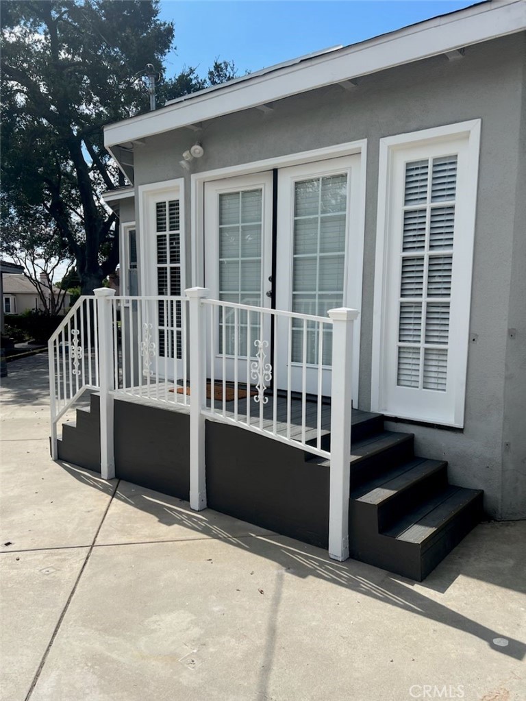 a view of a house with a deck and a floor to ceiling window