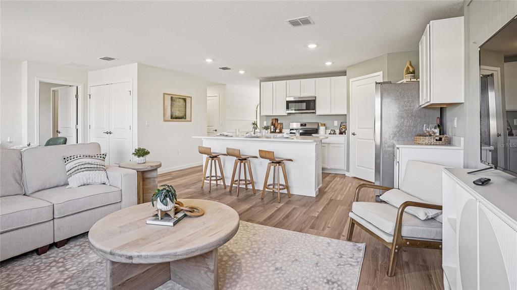 15880 Southeast 101st Ct Road Summerfield, FL 34491 - Photo 11 of 32 a living room with stainless steel appliances furniture a kitchen island a table and chairs