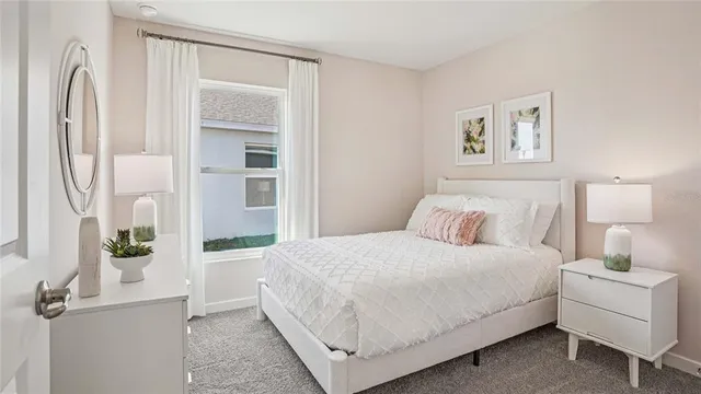 a bedroom with a bed painting on wall and a window